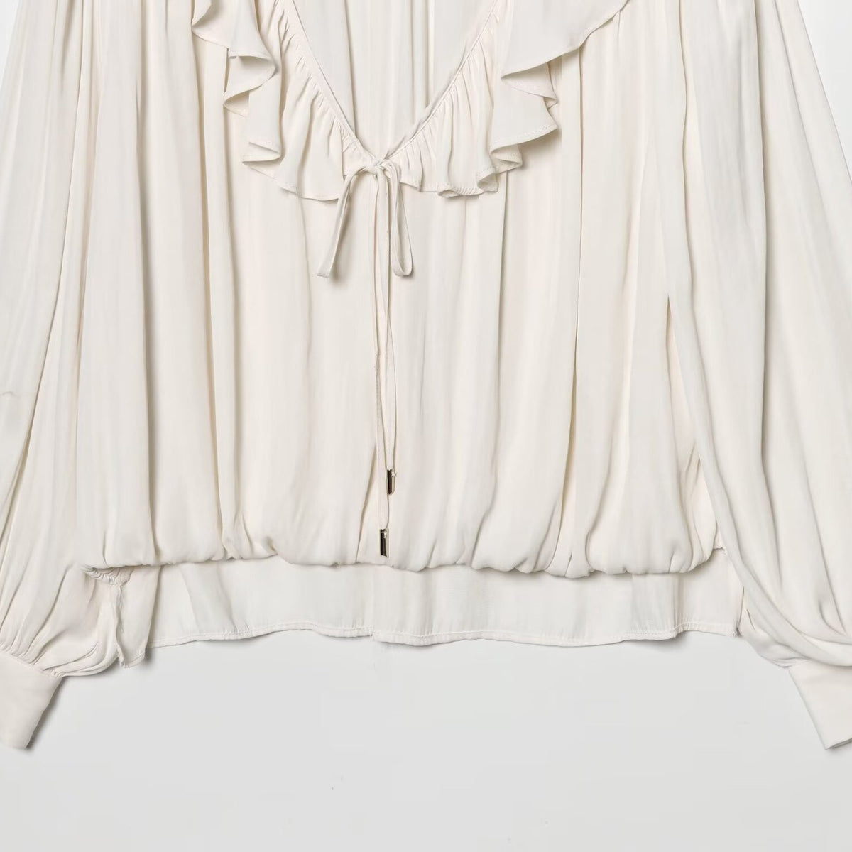 Blusa satinata con volant e maniche lunghe